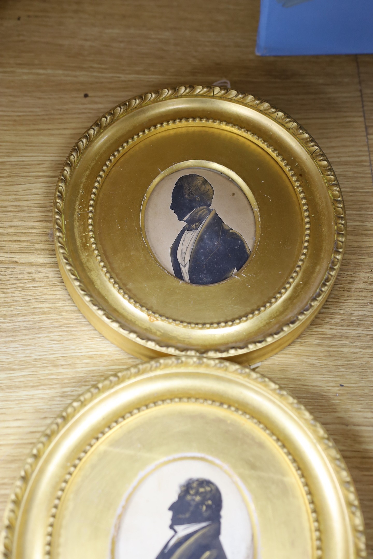 Victorian School, cut paper heightened with bronze, Silhouette of a gentleman, 8 x 6.5cm, with two similar silhouettes